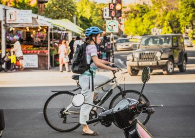 Jeune femme en vélo près d'un marché de fruits et légumes